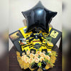 Graduation-themed gift arrangement with a black star balloon, yellow and black accents, Ferrero Rocher chocolates, roses, and congratulatory messages for the graduate.